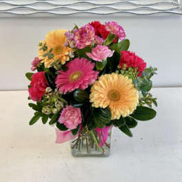 Mixed bouquet of gerbera daisies and carnations in a glass vase