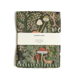 Folded woodland-print tea towel with mushrooms and trees