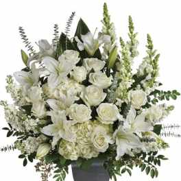 White lilies and roses arranged in a dark vase