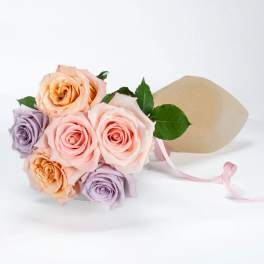 Bouquet of pastel roses wrapped in beige paper with a pink ribbon