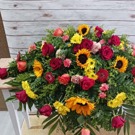 Large mixed floral arrangement with red roses and sunflowers