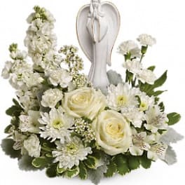 White floral arrangement with an angel figurine centerpiece