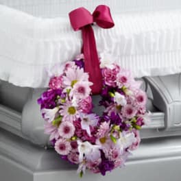 Pink and purple floral wreath with a magenta ribbon bow