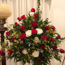 Large arrangement of red and white roses in a pedestal vase
