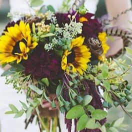 Bouquet with sunflowers and dark burgundy flowers in a vase