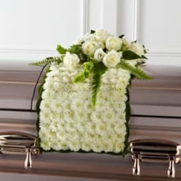 White floral casket spray with roses and chrysanthemums