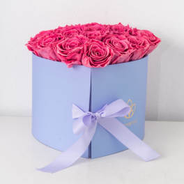 Hot pink roses arranged in a light purple hatbox with a matching ribbon bow.