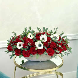 Red roses and white anemones in a low gray bowl