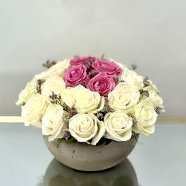 Pink and white roses arranged in a low round bowl