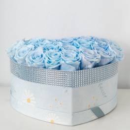 Heart-shaped box filled with light blue roses and wrapped with a silver rhinestone band