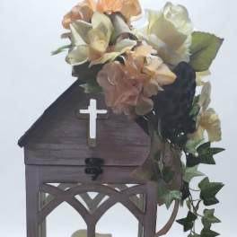 Lantern with cream flowers and a cross on the front