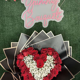 Heart-shaped red rose bouquet with white baby's breath and black wrapping