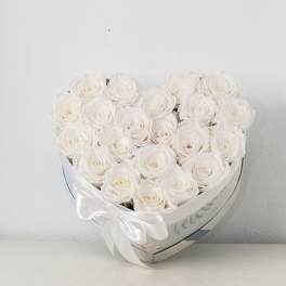 Heart-shaped box filled with white roses and tied with a white satin bow