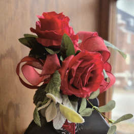 Red roses arranged on a memorial lantern with a framed tribute panel