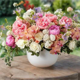 Pink and white floral arrangement in a white bowl vase