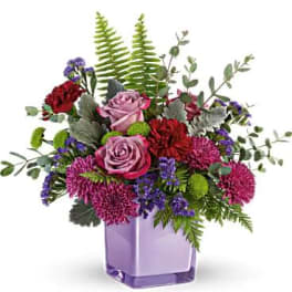 Purple and pink flower arrangement in a lavender vase