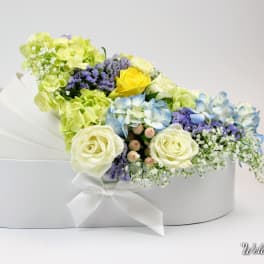 White hatbox arrangement with pastel roses, hydrangeas, and filler flowers
