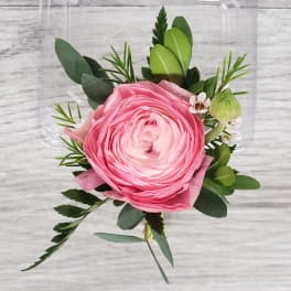 Pink ranunculus boutonniere with greenery and small white accents