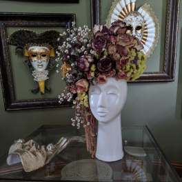 Floral headpiece on a white mannequin bust with purple and cream roses