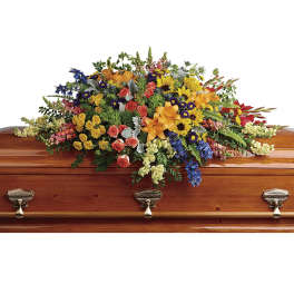Colorful floral spray arranged on a wooden casket