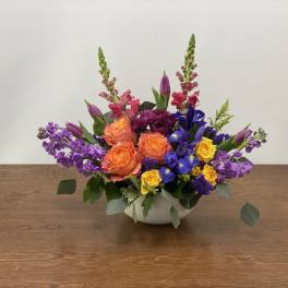 Colorful mixed flower arrangement in a white bowl vase