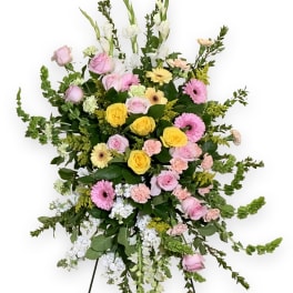 Standing floral spray with pink, yellow, and white flowers on an easel