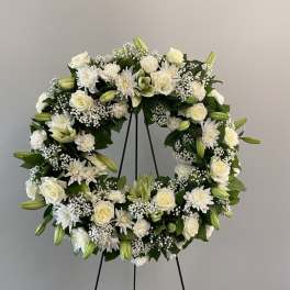 White floral wreath on a black stand
