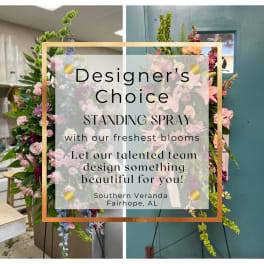 Standing spray with pink, peach, and purple flowers on an easel