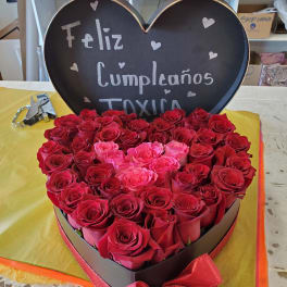 Heart-shaped box of red and pink roses with a birthday sign