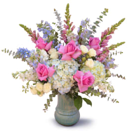 Pink roses and pastel flowers arranged in a blue vase