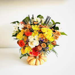 Mixed bouquet of roses and chrysanthemums in a pumpkin-shaped container