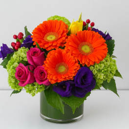Bright mixed bouquet in a glass vase with orange daisies and pink roses
