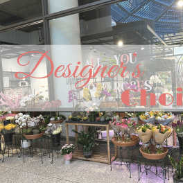 Flower shop window display with many bouquets and potted plants