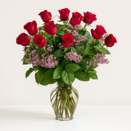 Red roses with pink filler flowers in a clear glass vase