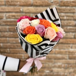 Bouquet of multicolored roses wrapped in black-and-white striped paper
