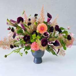 Purple calla lilies and pink dahlias in a blue vase