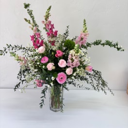 Pink and white mixed flower arrangement in a clear glass vase