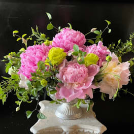 Pink and pale yellow flowers arranged in a silver vase