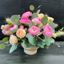 Pink and peach flowers arranged in a ribbed vase