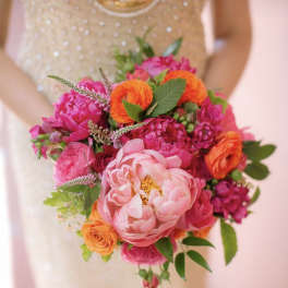 Bride holding a bright pink and orange bouquet