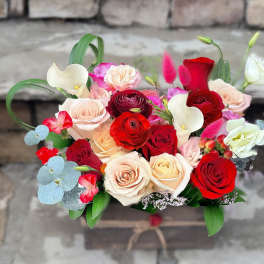 Rectangular wooden box filled with red and blush roses, white calla lilies, and mixed accent blooms