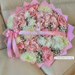 Pink bouquet of roses and white chrysanthemums with a birthday ribbon