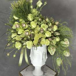 Lime-green floral arrangement in a white sculptural vase