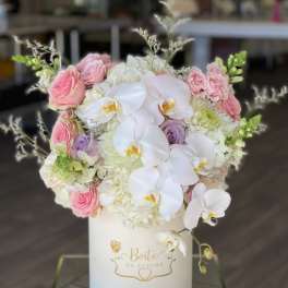 Pink and white floral arrangement in a white hat box
