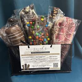 Gift basket of assorted chocolate-dipped pretzel rods in clear wrappers inside a black mesh container