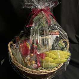 Gift basket with bananas, chocolates, and packaged snacks wrapped in clear cellophane