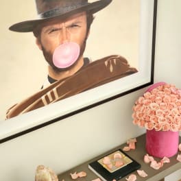 Pink rose arrangement in a cylindrical box on a shelf