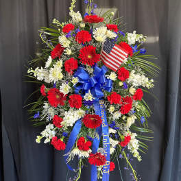 Standing patriotic floral spray with red, white, and blue flowers and an American flag