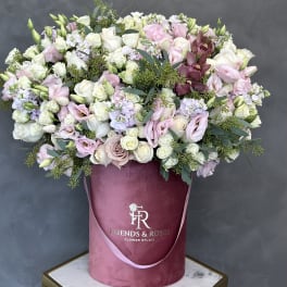 Large pastel bouquet of roses and lisianthus in a pink hatbox