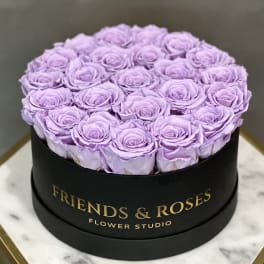 Lavender roses arranged in a round black box